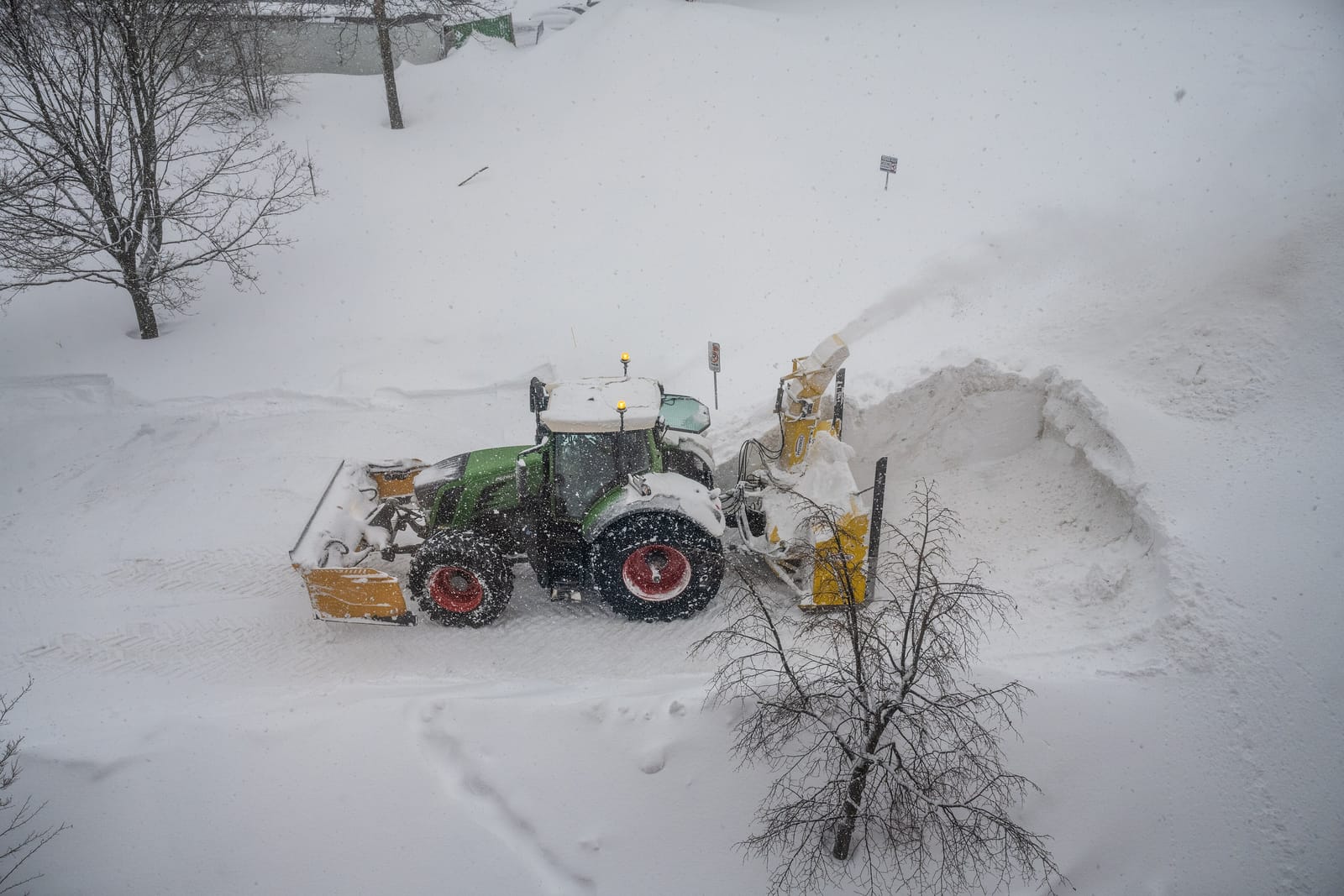 Souffleuse chargeant la neige dans un camion en milieu urbain