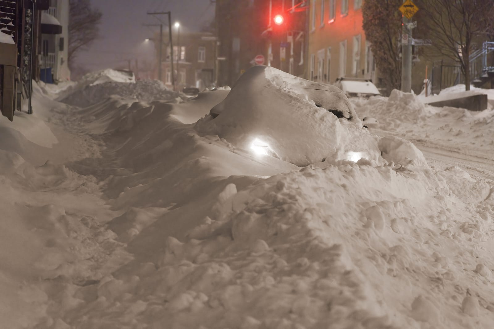 Déneigeuse dégageant un stationnement commercial durant une tempête